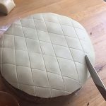 Cover the top of the cake with a disc of marzipan and score a criss cross pattern with a blunt knife. Cover the top of the cake with a disc of marzipan and score a criss cross pattern with a blunt knife.