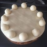 Roll 11 balls of marzipan and arrange around the edge of the cake securing with a dab of water or apricot glaze. Roll 11 balls of marzipan and arrange around the edge of the cake securing with a dab of water or apricot glaze.