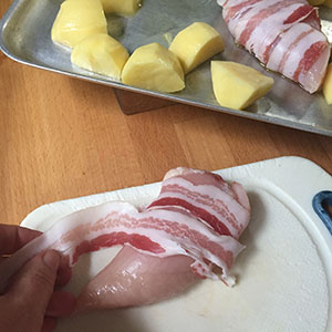 Wrap the chicken breasts in pancetta. Wrap the chicken breasts in pancetta.